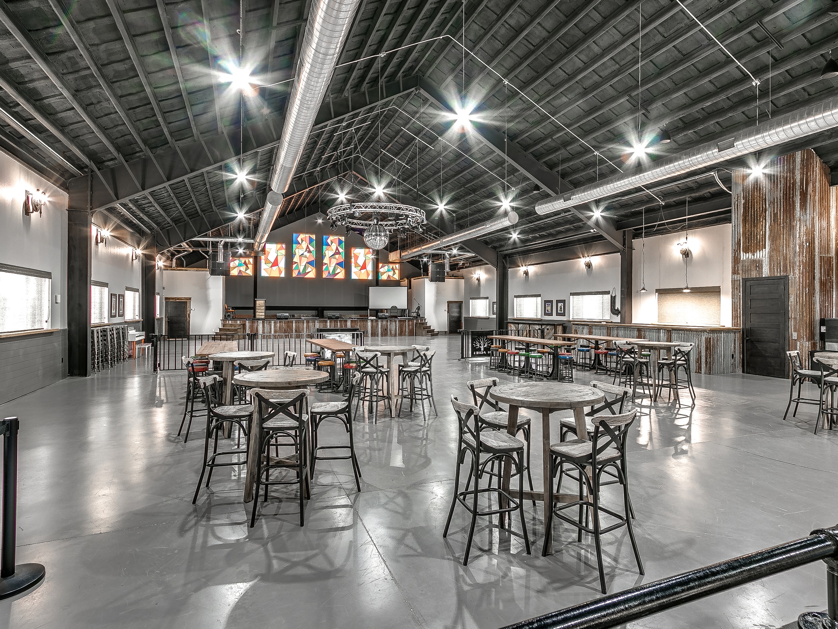 The Barn interior — soaring ceiling, stained glass, bar tables for events