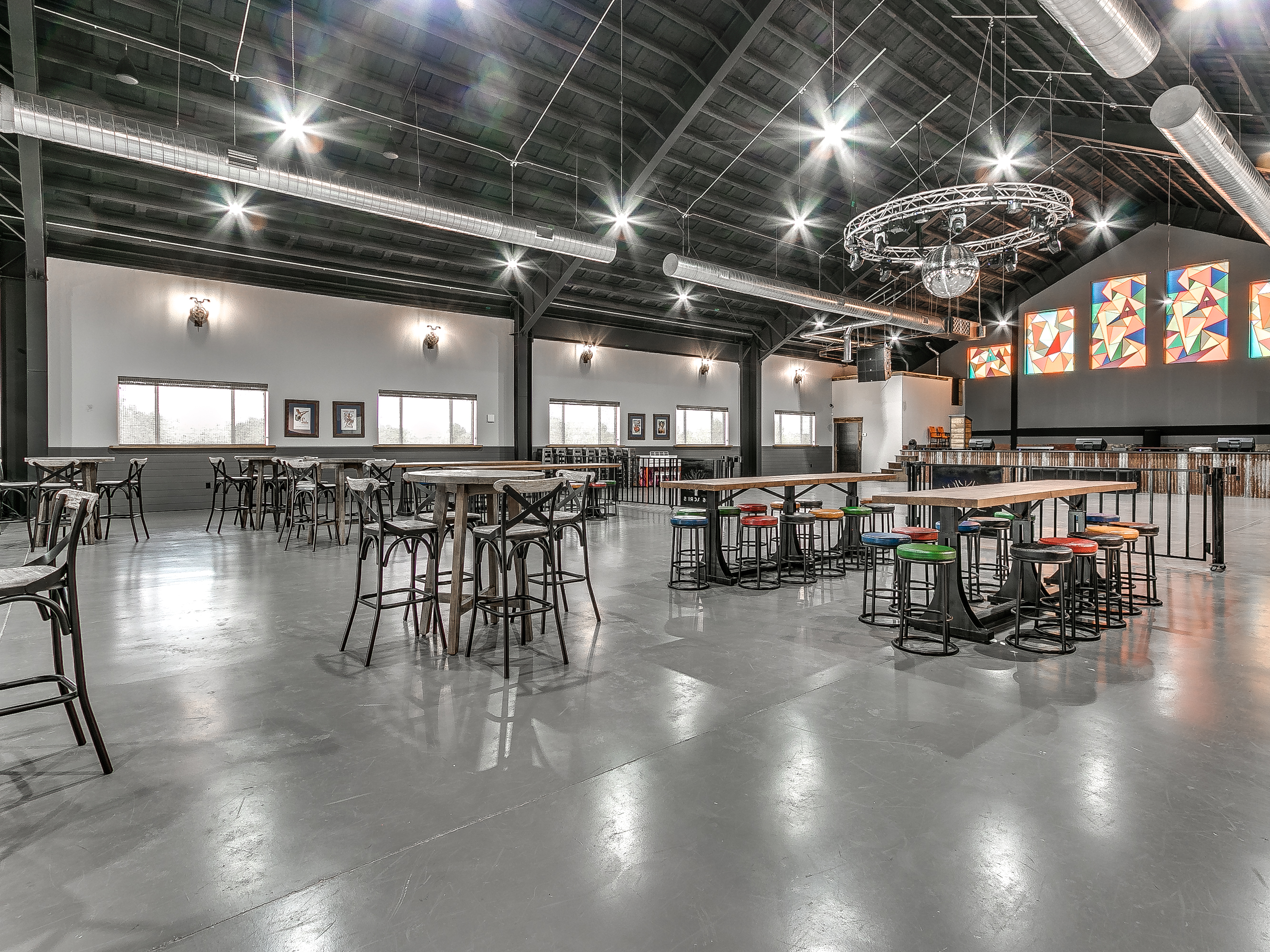 The Barn set with round dining tables under stained glass — ready for corporate retreats