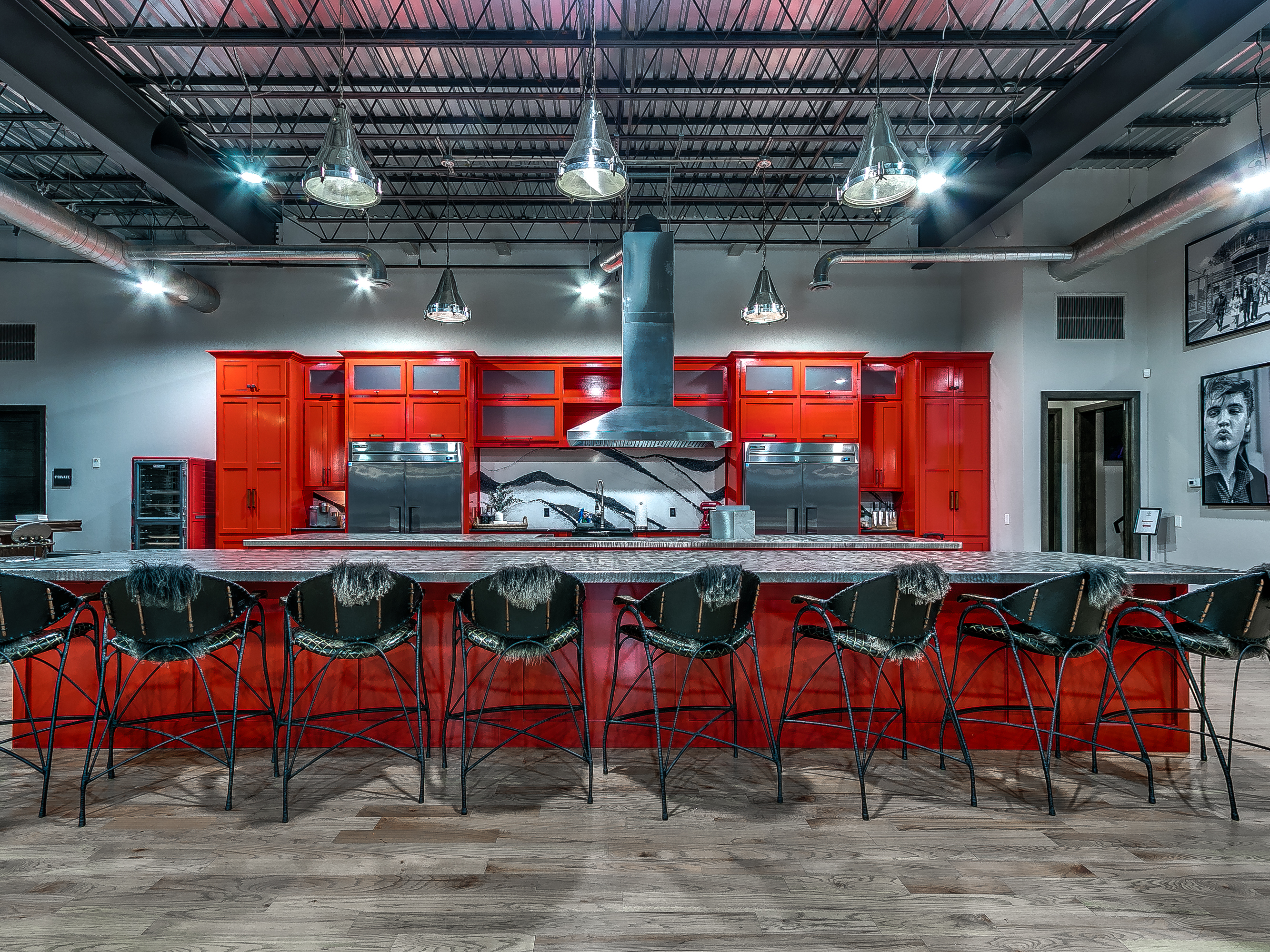 The 36 Acres branded kitchen — red cabinets, fur-lined bar stools, range hood