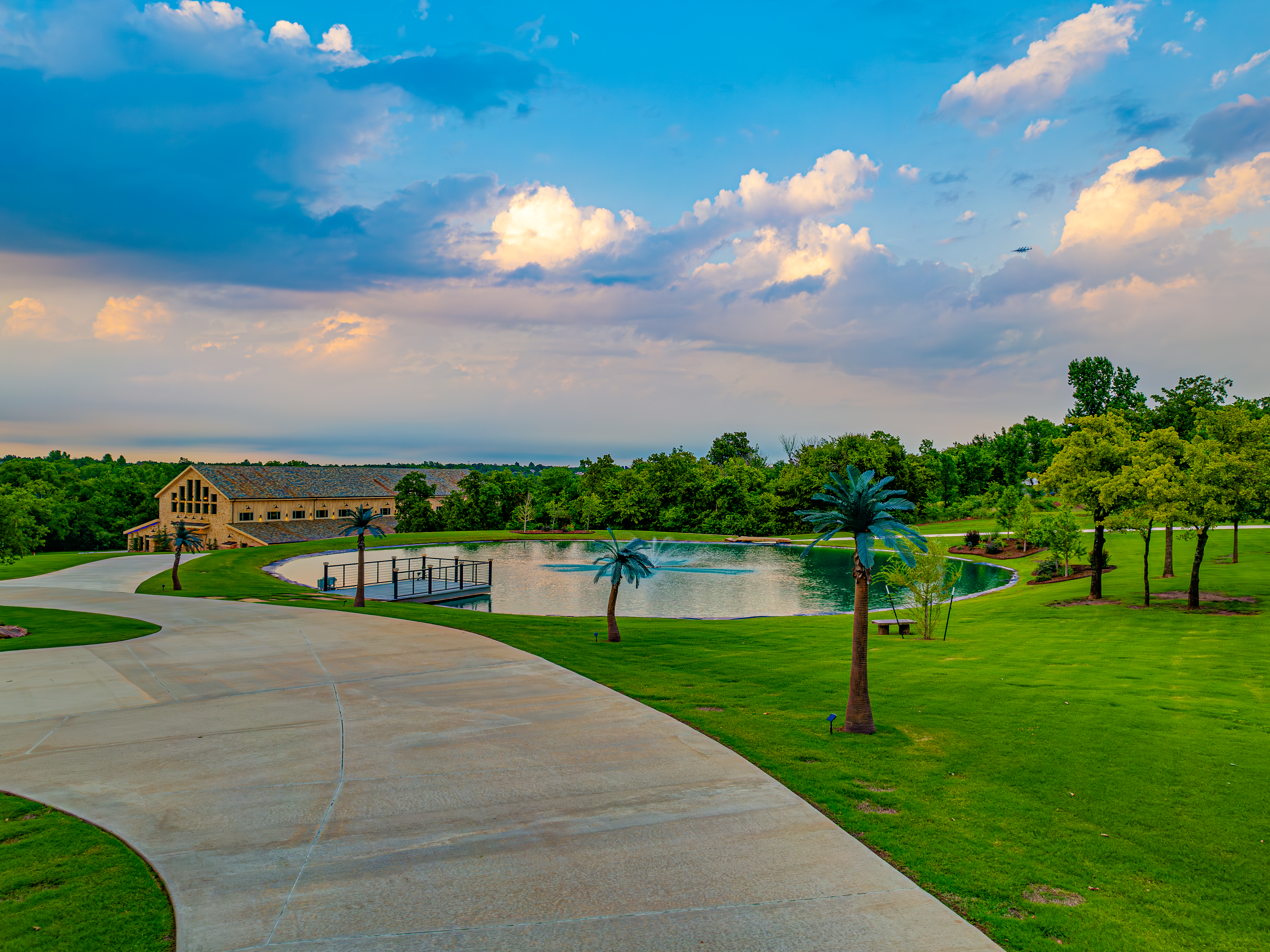 Elevated overview of the resort pool, barn, and grounds at sunset
